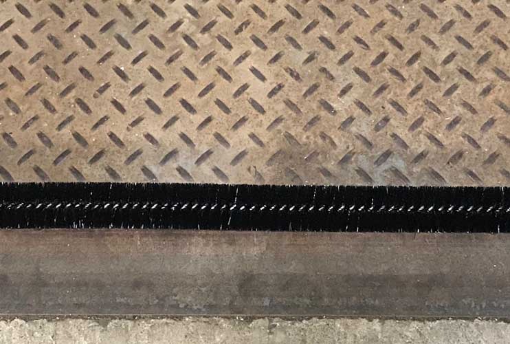 Spiral brush weather seal for dock levelers