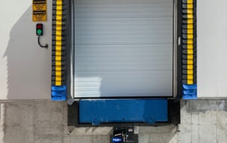 Blue Giant hydraulic elevating dock leveler plate, steel face dock bumper, electric hook trailer vehicle restraint HVR303, stationary dock seal 101, steel sectional overhead vertical lift door