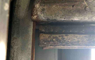 overhead drive-in sectional door preventive maintenance PMP Before - Position 2 – Drive-In Door - Bottom bracket being sheared by track from being off level.