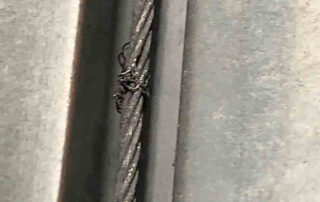 overhead drive-in sectional door preventive maintenance PMP Before - Position 2 – Drive-In Door - Frayed left cable which is at risk of snapping.